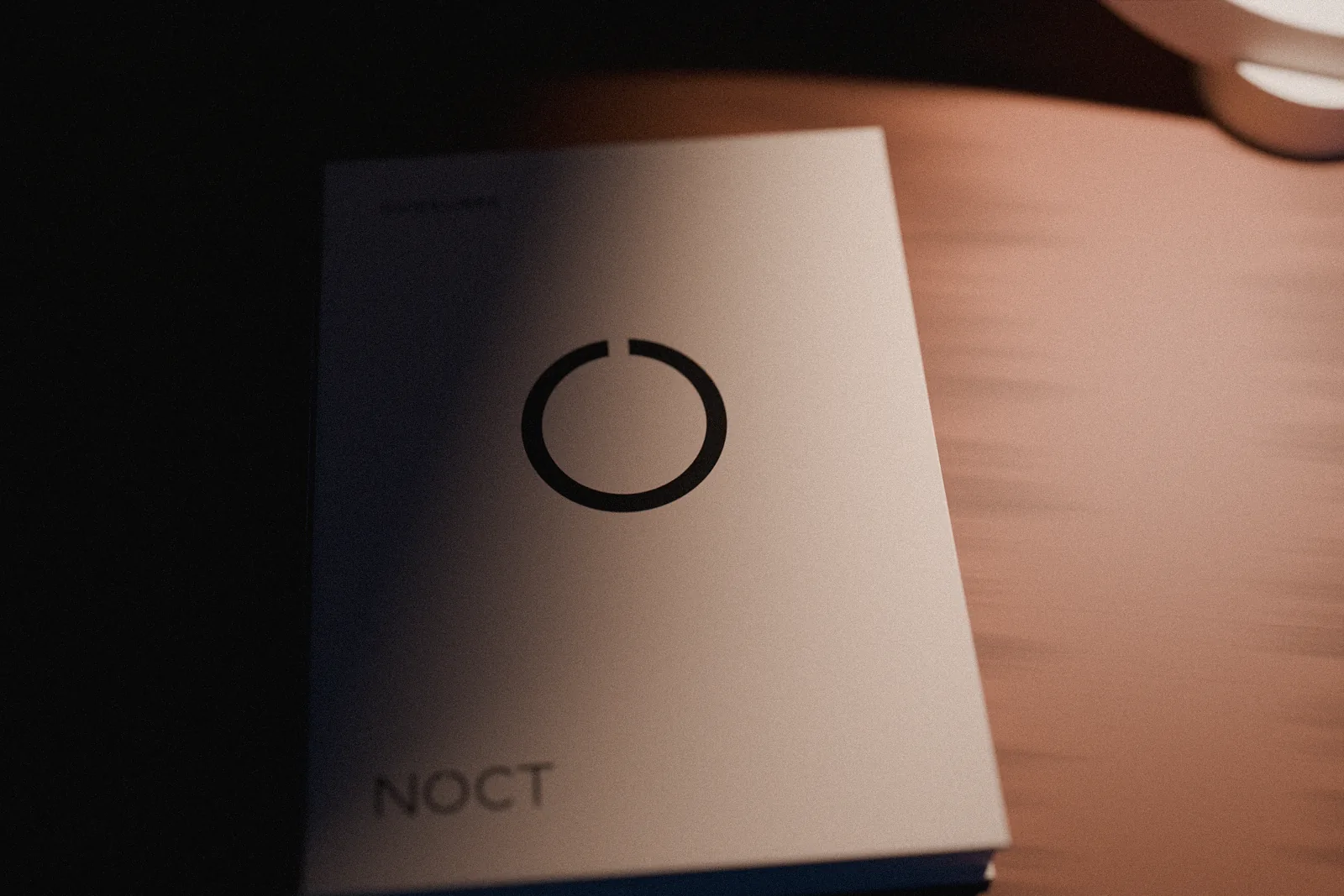 The NOCT guideline as a small hardcover book on the table next to the lamp, the mark on its cover.